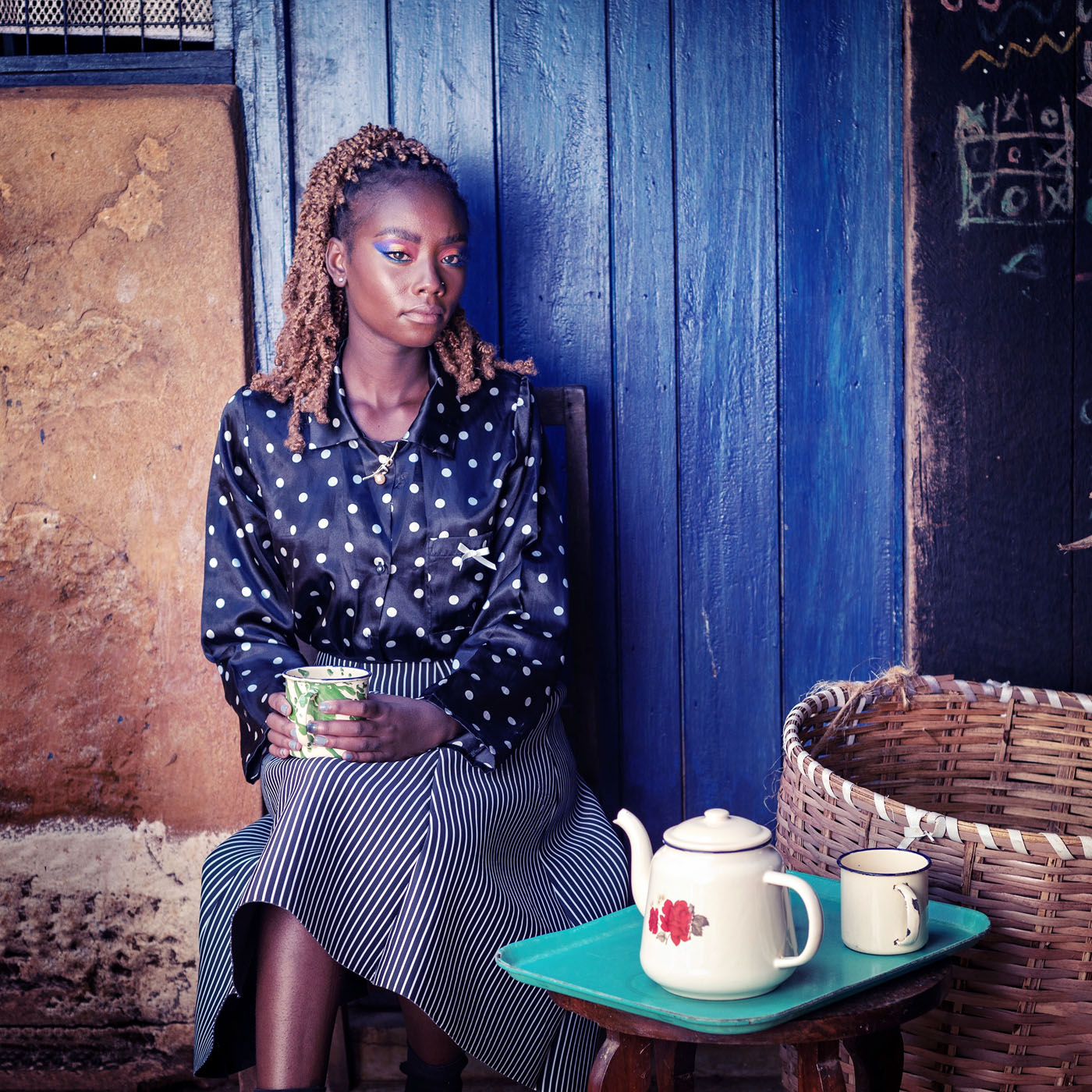 Portrait of young African woman holding a metal mug of tea