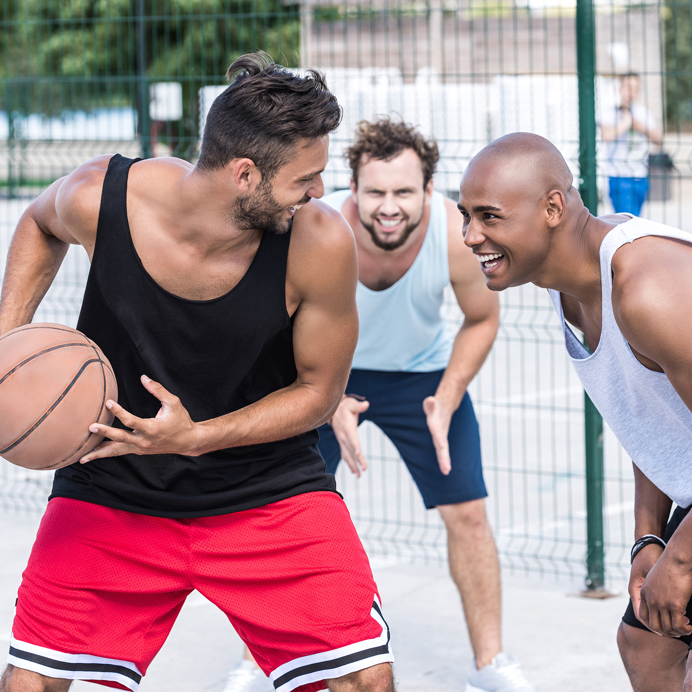 multiethnic group of basketball players playing basketball on court