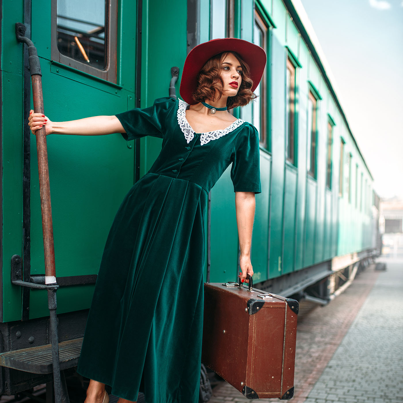 Woman in red hat on vintage steam locomotive. Old train. Railway engine, railroad journey