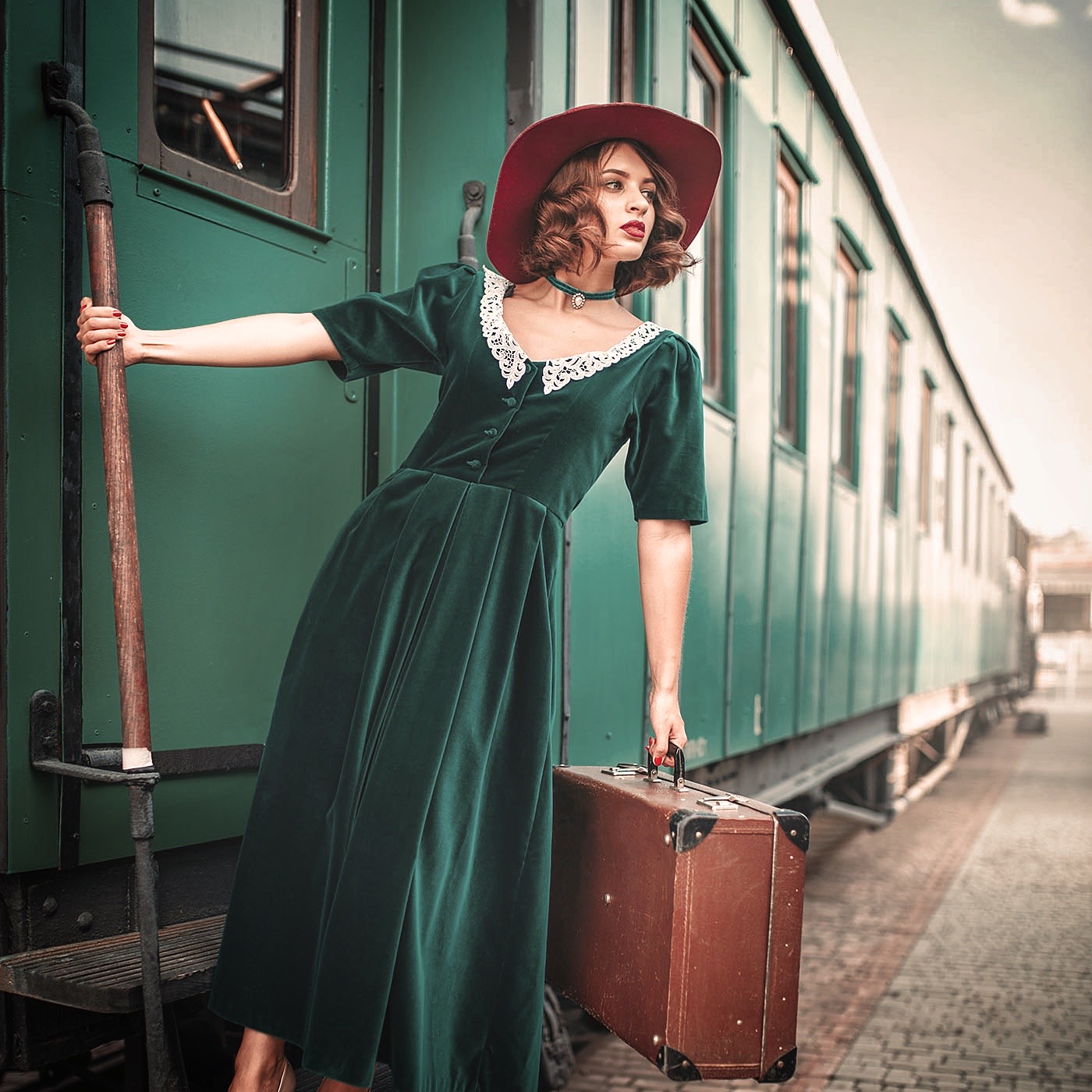 Woman in red hat on vintage steam locomotive. Old train. Railway engine, railroad journey