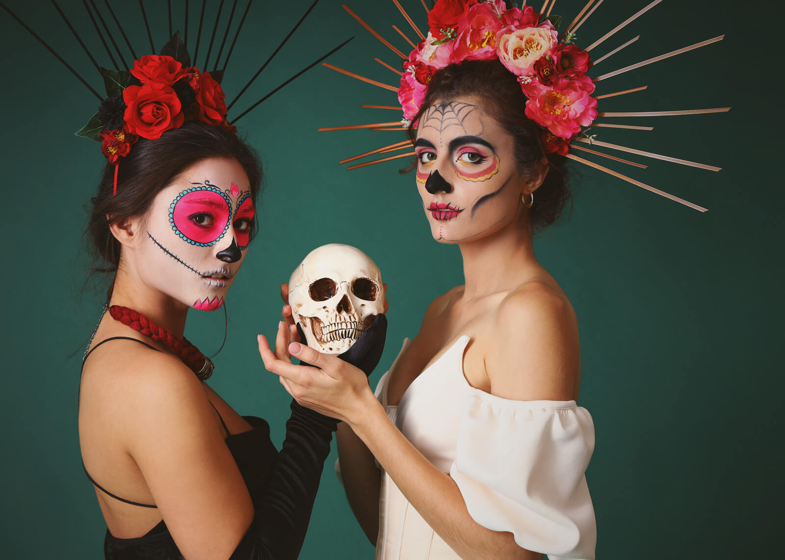 Women with painted faces and skull on dark green background. Celebration of Mexico's Day of the Dead (El Dia de Muertos)