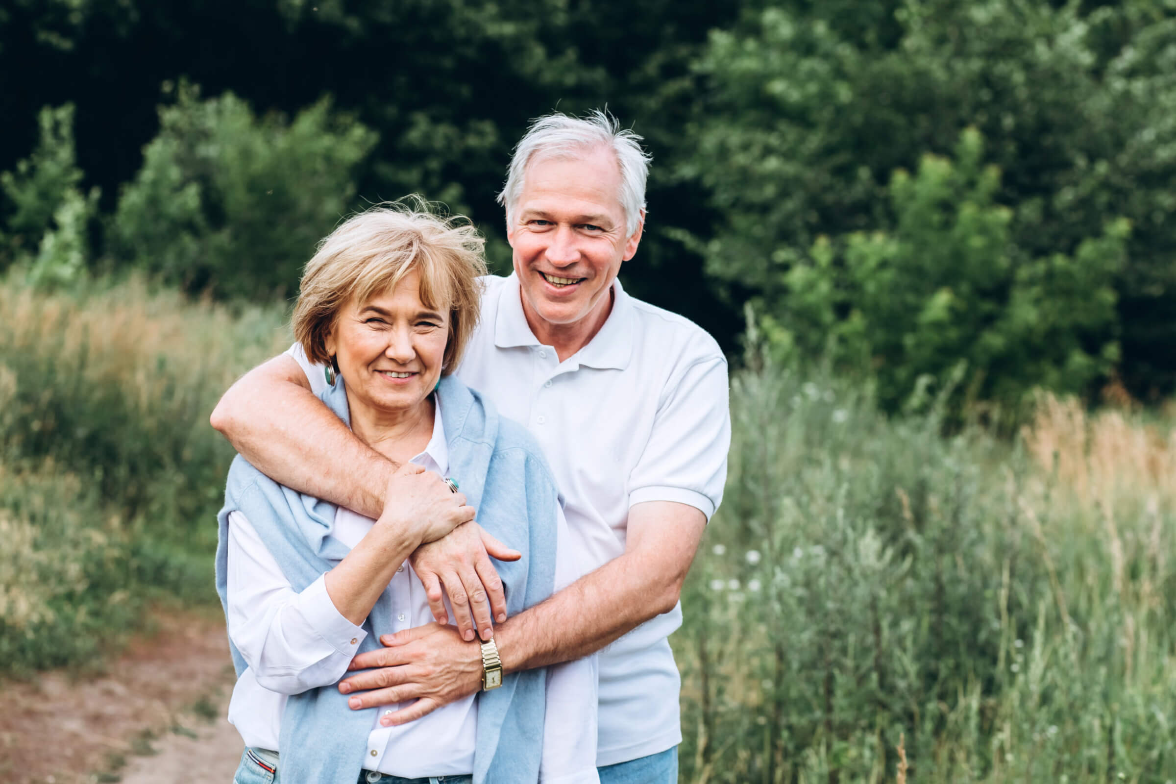 the old couple walks in nature, hold hands, cuddle