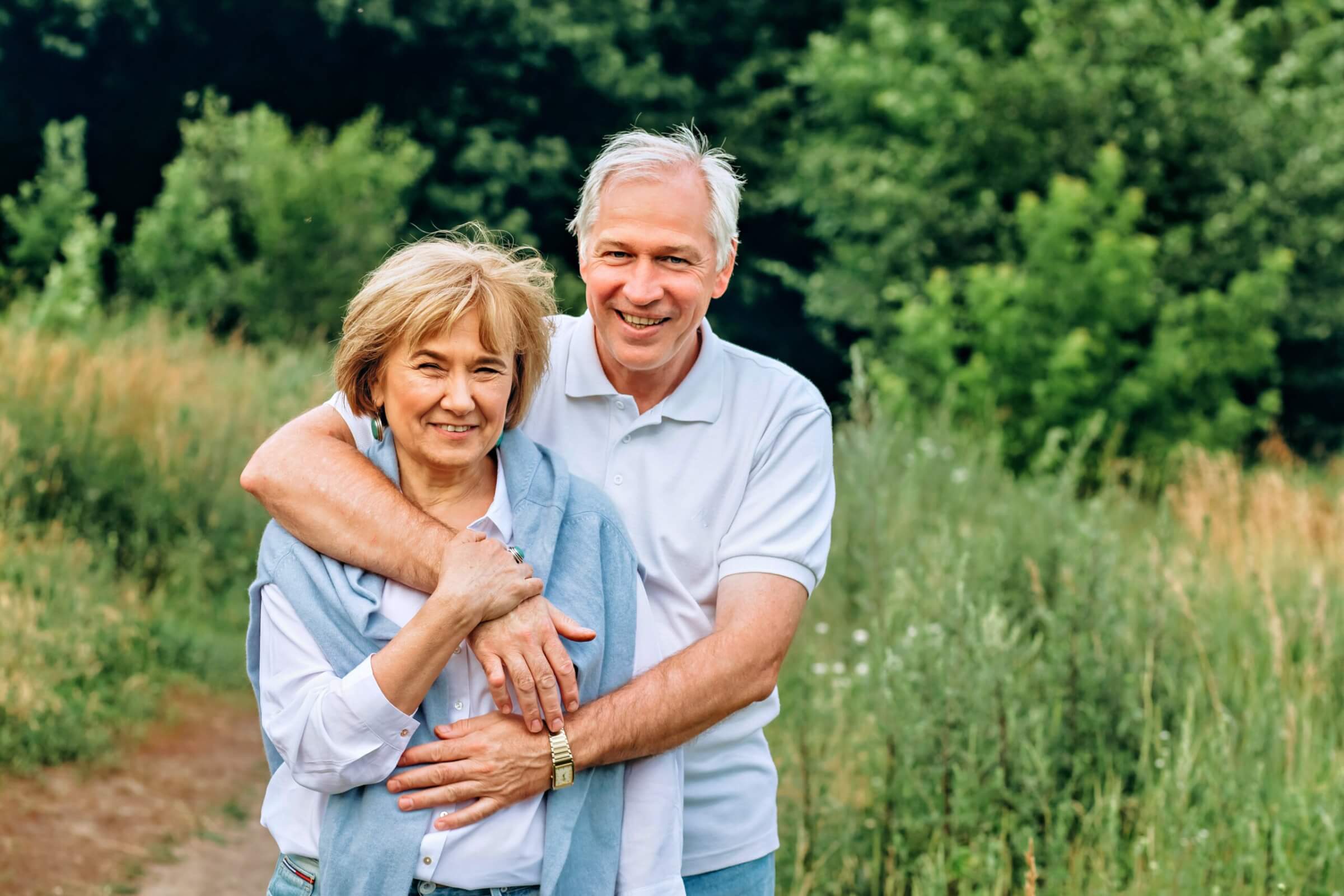 the old couple walks in nature, hold hands, cuddle