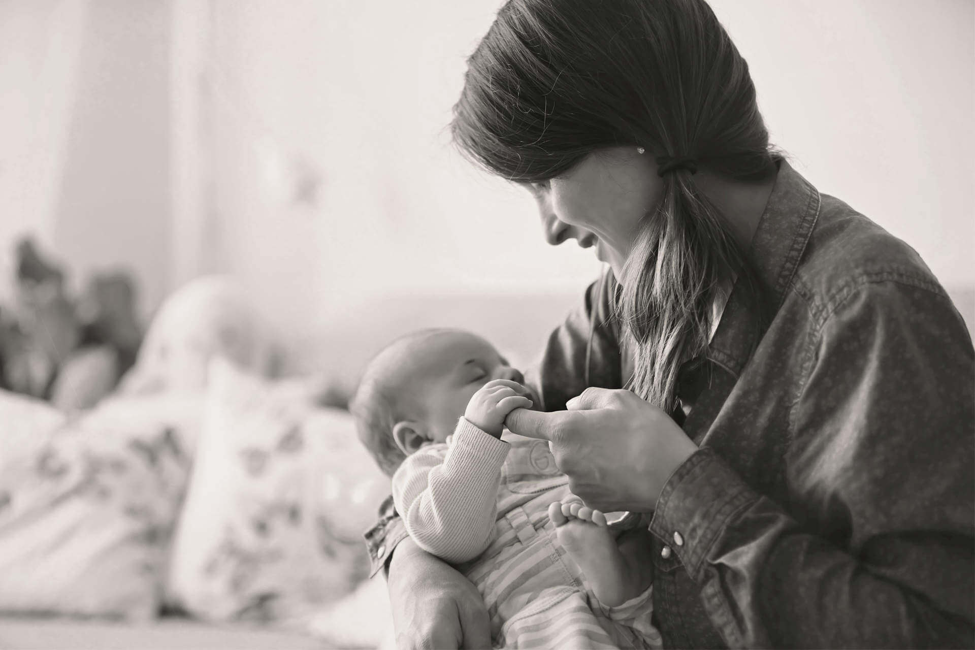 Young mother, kissing her newborn baby boy at home, mom and baby, embracing with love, emotional. Family concept