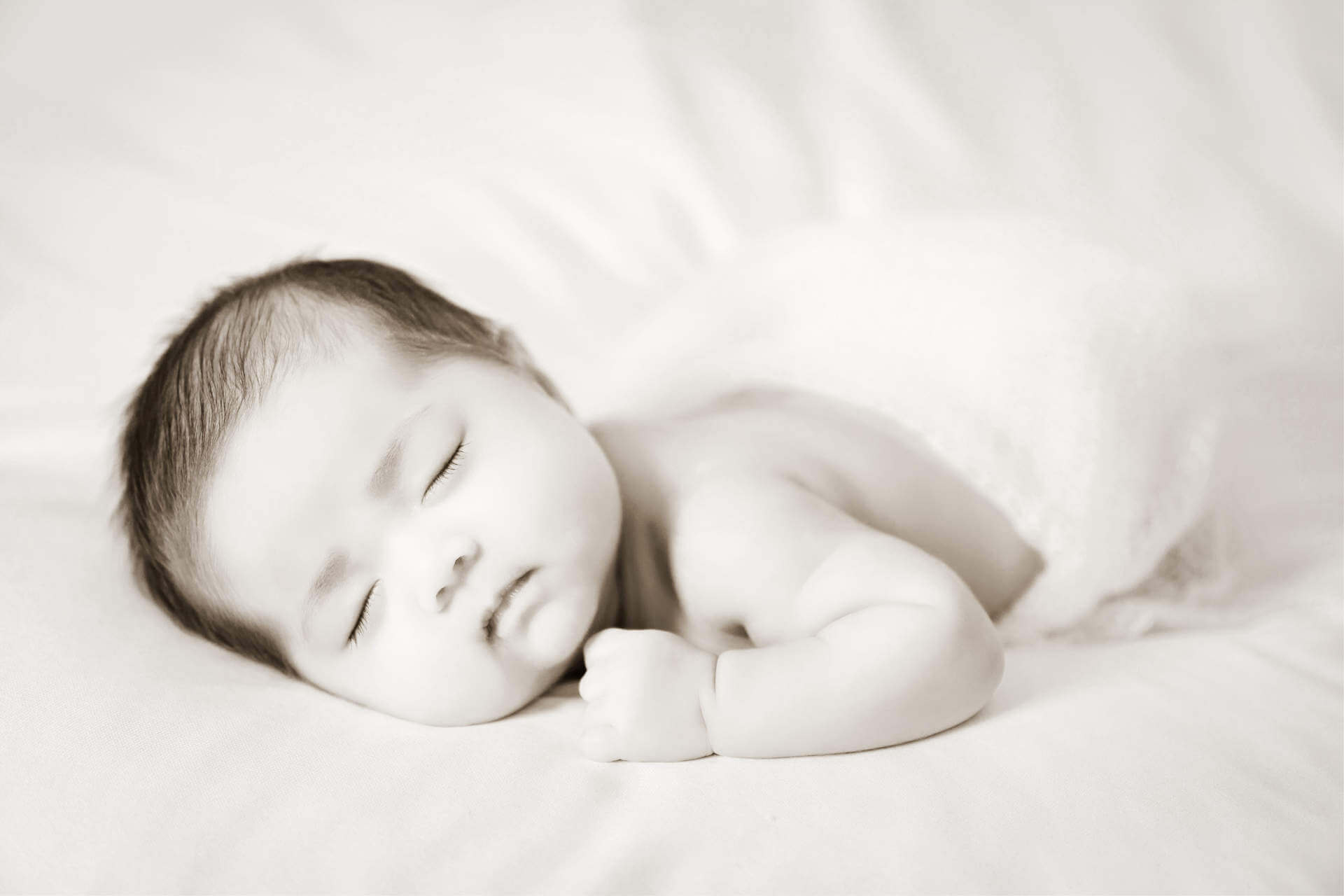 Adorable asian newborn baby in pink wrap sleeping on white blanket background. Portrait of newborn girl sleep on bed.
