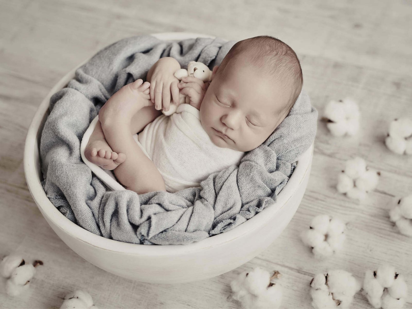 Cute newborn little boy sleeping in crib with toys. Baby goods packaging template. Closeup portrait of newborn baby with smile on face. Healthy and medical concept.
